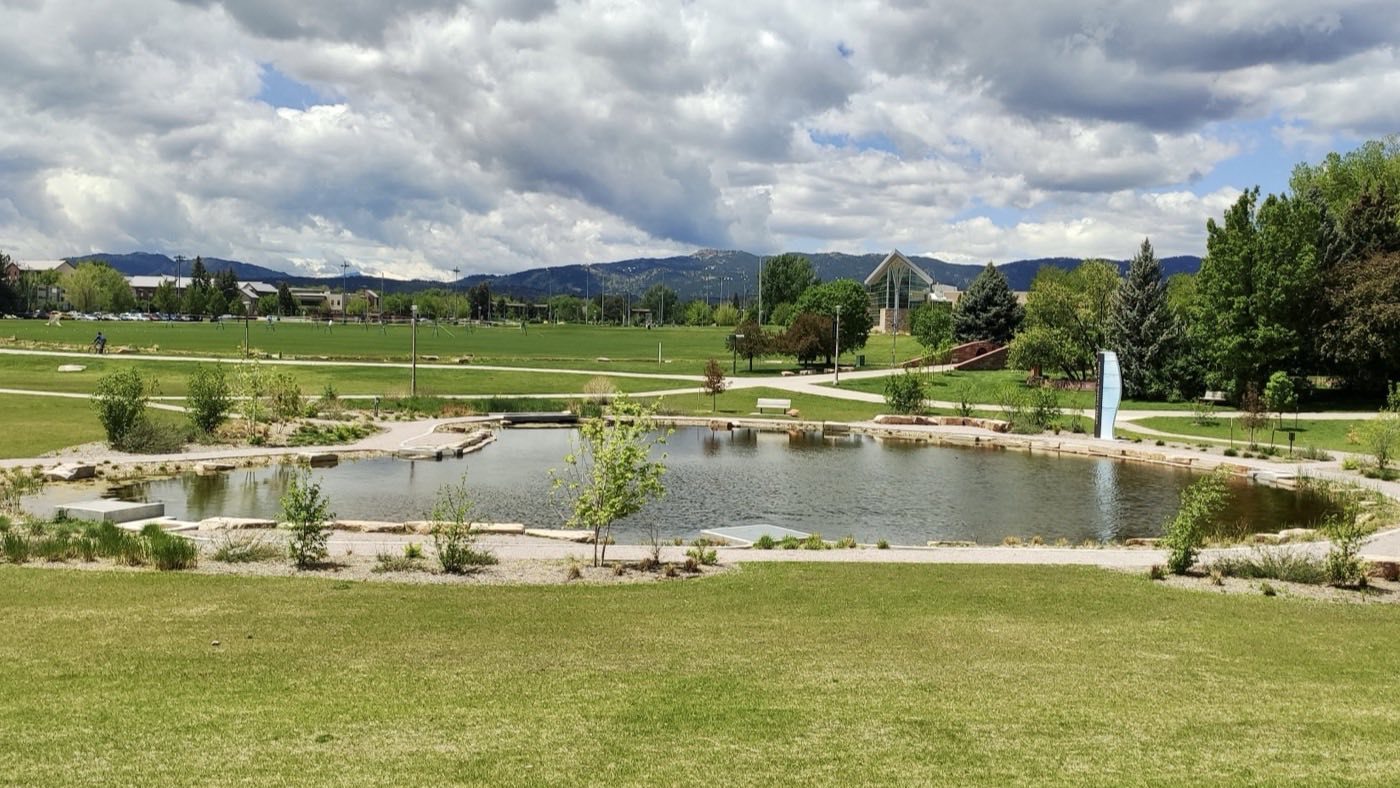 The lawn and pond outside the Lory Student Center at Colorado State University, with the foothills beyond.